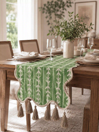 Botanical table runner in sage green with a leafy branch pattern down a wooden dining table