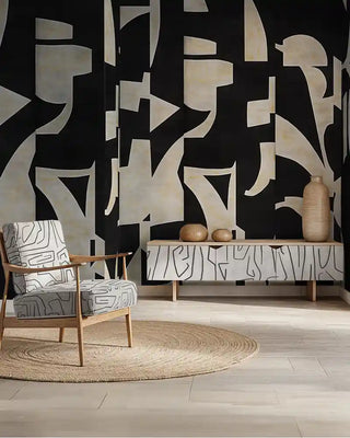 A guest room with black and white abstract wallpaper. Features a modern wooden console, decorative vases, and an upholstered armchair on a jute rug.