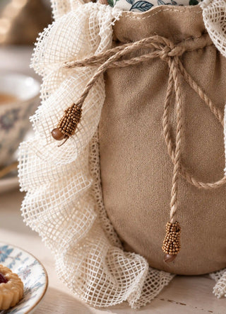 The Grandeur Ruffle jug cover in Taupe, view-detail of ruffled lace trim and beaded tassel drawstring.