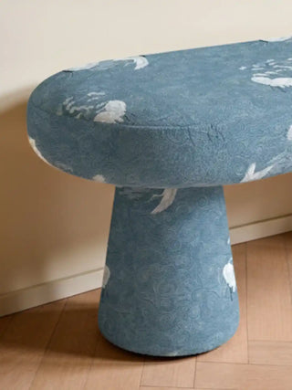 A contemporary mushroom-style upholstered bench featuring the Graceful Cranes blue linen fabric in a minimalist interior.