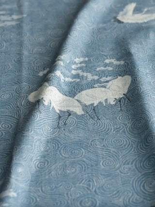 A close-up of the soft folds of the Graceful Cranes linen fabric, highlighting the textured weave and detailed crane illustrations.