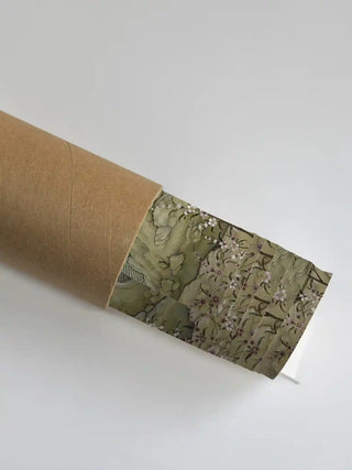 Close up of the Phoenix Painting mural's sage green textures and floral details emerging from a rolled packaging shipping tube.