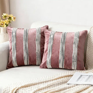 Blush Braid Cushion Cover: Soft blush velvet cushions detailed with chic black and white braided stripes. Styled on a cozy neutral sofa.