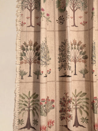 close-up focusing on the left side edge of the curtain panel against the wall. The texture of the fringed lace trim is prominent, showing the artisanal detail. This image highlights the rich texture of the woven linen...