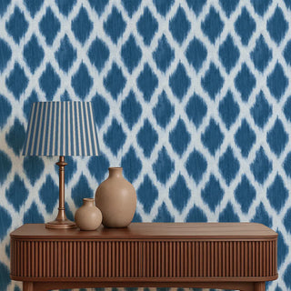 Wooden console table with decorative items against a blue and white patterned wallpaper