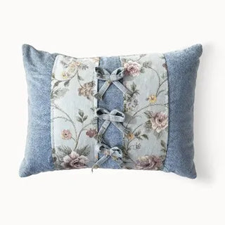 Floral tapestry cushion with blue velvet sides and three bow details.