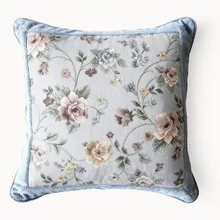 Square floral tapestry cushion with blue rope cording trim.