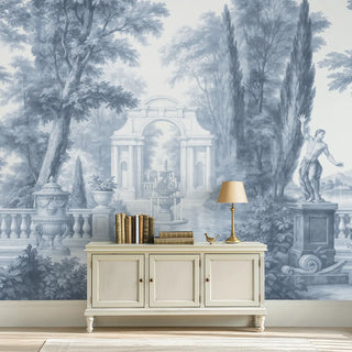 Beige sideboard with books and a lamp against a decorative wall mural of classical architecture and statues.