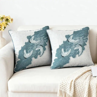 The Graceful Cranes Patch Cushion Cover: Featuring cranes over a blue panel. The mix of natural linen and patchwork gives it a refined, contemporary appeal. Styled on a cozy neutral sofa.