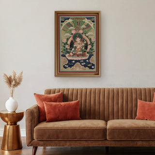 Green Tara Buddhist Indian Wall Art framed above a brown velvet sofa with rust cushions, creating a warm, meditative interior atmosphere.