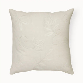 A soft beige cushion cover with delicate white vine embroidery, adding subtle elegance.