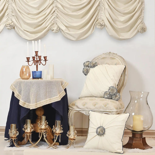 Decorative room setting with a chair, lamp, and floral cushions.