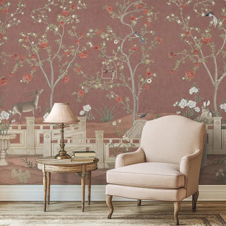 Beige armchair and wooden table in front of decorative wallpaper with floral and animal patterns.