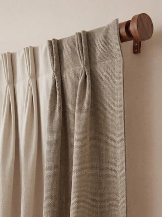 Kanan Readymade Curtain readymade curtain, close-up view of the curtain's top edge hung gracefully on a warm wooden rod. It features expertly tailored pinch pleats, illustrating the crisp, seamless transition between...