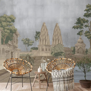 Two wicker chairs with a decorative table against a wall mural of an ancient cityscape.