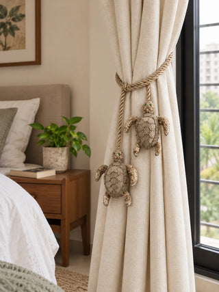 Kurma turtle charm tieback holding back a linen curtain in a bedroom