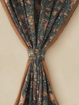 detailed close-up of a Majestica curtain panel elegantly tied back with a matching fantasy print tie-back. The center features a complex European fantasy tapestry print with creatures like an ibex, unicorn, and griffi...