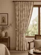 Room interior with floral Nritya curtains, a bed, and a window.