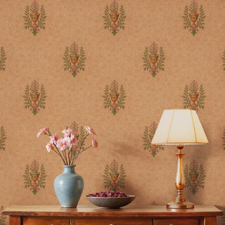 A wooden side table with a lamp and a vase of flowers, set against a wall with a Peshwai-style floral urn wallpaper.