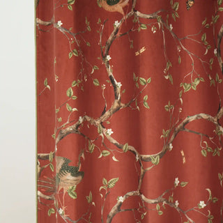 Close-up view of Phoenix Chinoiserie Readymade Curtain showing intricate embroidery of peacocks and blooming branches on a rich terracotta base.