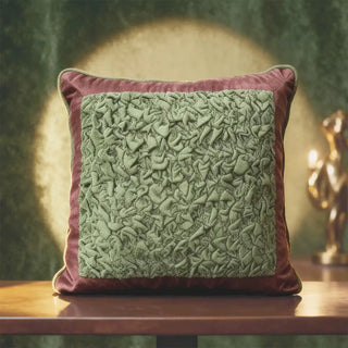 Sage Cushion Cover: Soft sage center ruched cushion detailed with Green ruched velvet on the center framed with pink velvet. Styled on a table in moody environmemt.