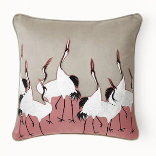 Sedge Pink Cushion Cover: Front view of a cushion featuring embroidered cranes set against a soft pink fabric patch, it pairs beautifully with a warm beige base for a refined, modern contrast.