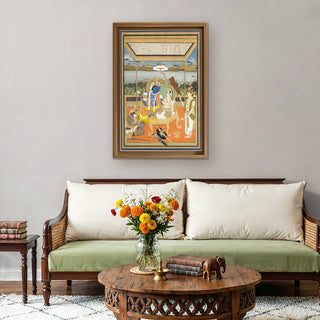 Shri Ram Parivar Indian Embroidered Wall Art framed above a traditional wooden sofa with soft beige cushions and marigold florals, blending spirituality with modern decor.