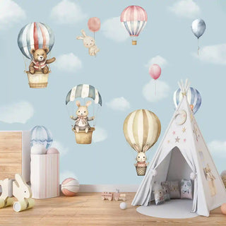 Sky Dreams hot air balloon kids wallpaper in a playful nursery setup with a teepee tent, pastel balloons, and cute animal characters floating in the sky.