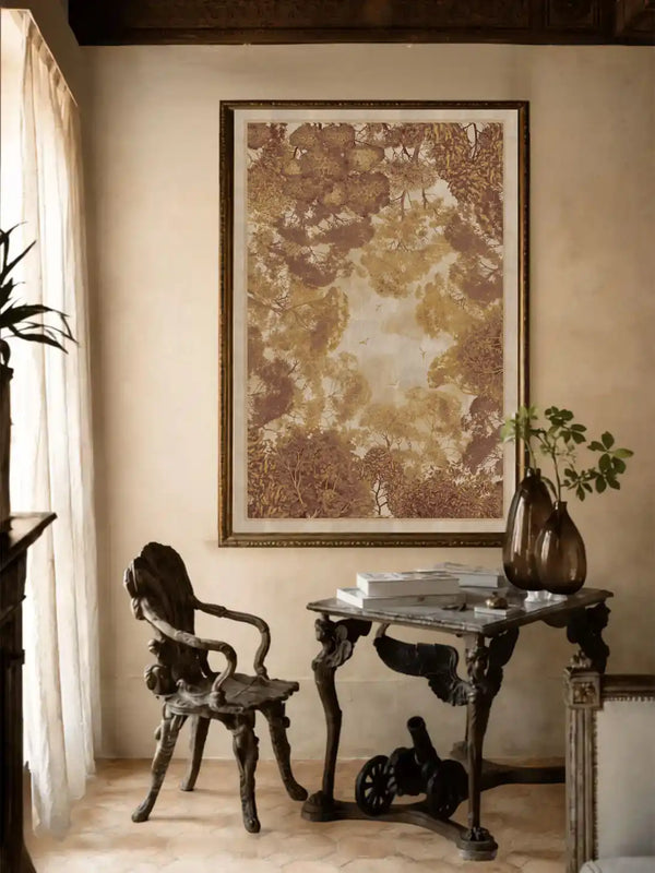 The framed wall art hangs above an ornate dark wood console table paired with a vintage carved wooden chair. Ambient lighting and sheer window curtains enhance its classic, sophisticated room setting.