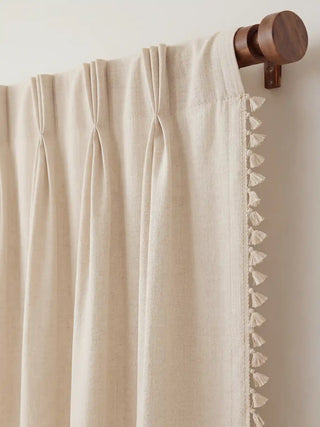 focused view of the curtain's top edge, illustrating the crisp, professional pinch-pleat tailoring. The header hangs elegantly from a dark, turned wood rod, clearly displaying the seamless integration of the delicate...