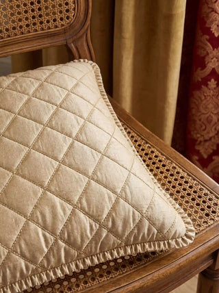 A side-angle close-up highlighting the thick quilted profile and gathered ruffled flange border of the Rukhsar gold throw pillow.