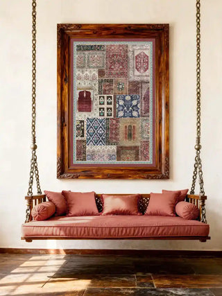Aalishan wall art in a carved dark walnut frame hung above a traditional Indian wooden swing jhoola with rose-pink cushions and brass chain on a white wall