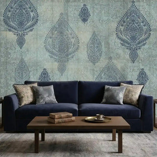 A sophisticated living room featuring the Afsana mural behind a deep blue velvet sofa with heritage-print cushions.