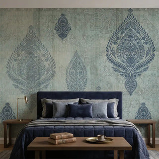 A luxury bedroom featuring the Afsana Blue distressed mural behind a dark navy velvet bed and wooden furniture.