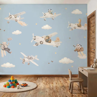 A sophisticated kids' bedroom featuring the blue aviator animal mural next to a modern wooden desk and activity rug.