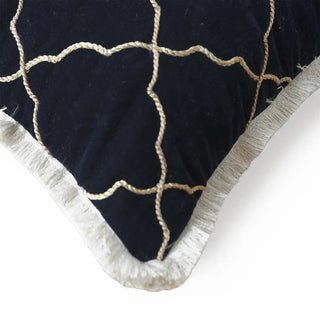 A close-up detail of the Amer Lattice cushion showing the raised gold cordage and the ivory eyelash fringe border.