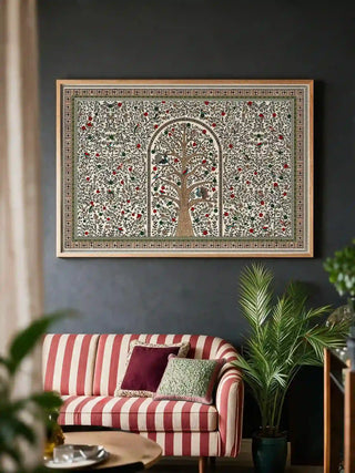 The Anant Madhubani wall art (horizontal) framed and hung on a dark accent wall above a striped sofa, showing a tree of life with peacocks and small birds in an arched niche, framed by a dense floral v