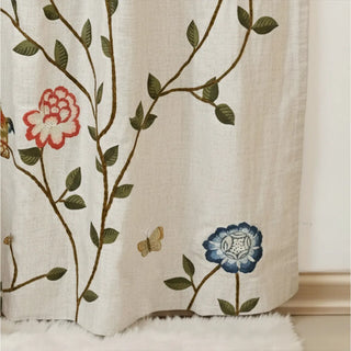 Lower section of Anar Bloom Curtain with butterflies, red pomegranates, and blue floral patterns on linen-textured fabric.