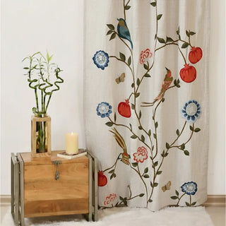 Full view of Anar Bloom Curtain featuring colorful motifs of pomegranates, flowers, and perched birds on a soft beige fabric background.