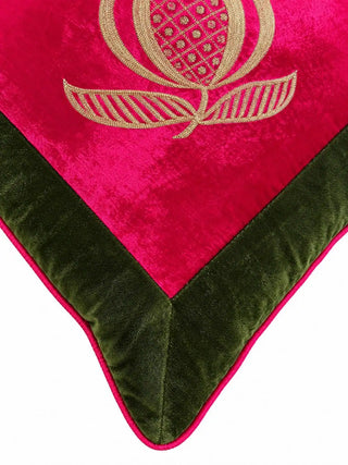 Close-up of the Anarkali cushion: a gold pomegranate with a lattice-filled centre and striped leaves on fuchsia velvet, above the olive border.