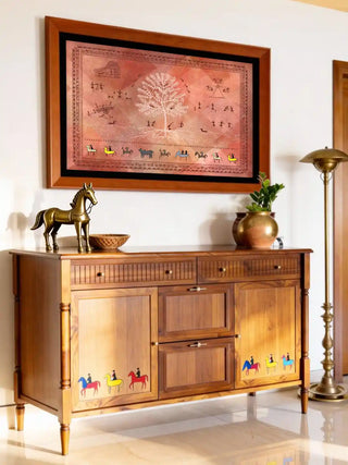 Ancient Warli mural in sunset clay above a hand-carved wooden sofa in a luxury living room.
