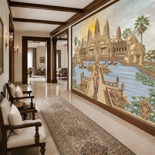 The Angkor Wat wallpaper mural in Gold & Sepia installed on a feature wall in a hallway, depicting the temple's towers, a causeway with naga balustrades and ceremonial elephants beside classic wooden armchairs. view-foyer