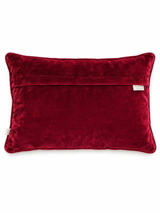 The reverse of the Annar Bagh cushion cover in plain red velvet with an overlap closure, red piping and a woven brand label.