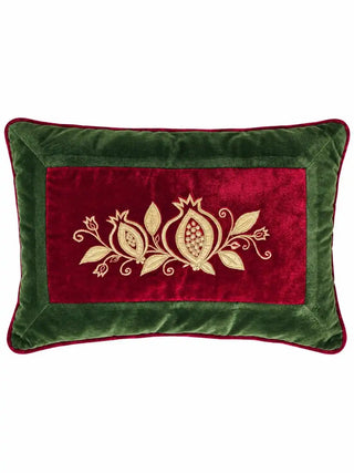 The Annar Bagh lumbar cushion cover showing a red velvet panel with a gold-embroidered pomegranate sprig inside an olive green velvet border.