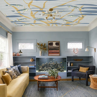 The Aqua Whispers ocean lattice ceiling wallpaper styled in a contemporary blue living room featuring an aquarium and mustard sofa  view-ceiling