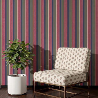 Arang upholstery fabric in ivory berry on a brass-framed accent chair beside a fiddle leaf fig, against berry and olive striped walls in a living room corner.