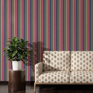 Arang upholstery fabric in ivory berry on a two-seater sofa with a light wood frame, set against multicoloured striped walls in a living room.