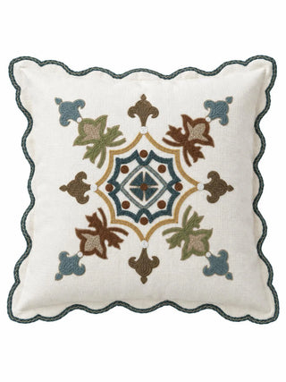 The front of the Avsar cushion cover: an eight-pointed medallion in teal, olive, rust and mustard-gold stitching at the centre of an ivory square, framed by a teal scalloped edge.
