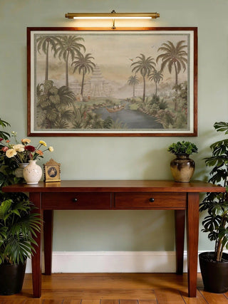 The Bali wall art print styled in a gold frame above a console table with a classical bust and brass lamp.