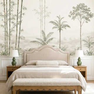 Bamboo Groves tropical wall mural in muted sage and mist behind an upholstered bed with neutral linen bedding in a calm, nature-forward bedroom